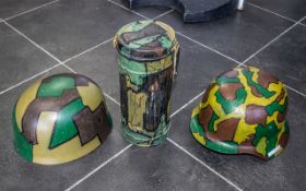 Two German Steel Helmets, and a Gas Mask Holder, all painted in camouflage paint. One with liner.