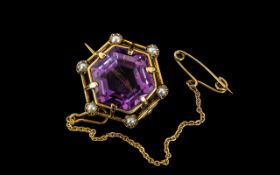 An Early 20thC Amethyst Brooch set with seed pearls in yellow metal. 20mm wide.