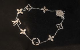 A Louis Vuitton 18ct White Gold Bracelet a link change with various shaped charms and LV logo.