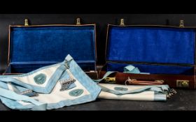 Two Masonic Leather Cases Containing two aprons, books, silver jewel and a gilt jewel.