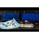 Two Masonic Leather Cases Containing two aprons, books, silver jewel and a gilt jewel.