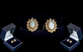 9ct Gold Opal Earrings, oval shape opal surrounded by white stones, in a 9ct setting.