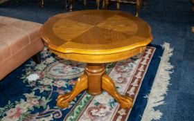 Round Polished Oak Coffee Table, raised on a central pedestal with three splayed legs and claw feet.