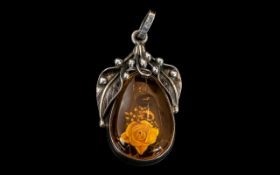 A Silver Art Nouveau Style Amber Set Pendant Drop height with bale 2 inches.