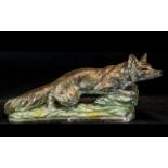 A Large Decorative Figure of a fox crouching on a rock. Measures 50 cms in length by 30 cms in