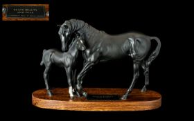 Beswick 'Black Beauty & Foal' raised on a wooden base. Measures approx 8'' tall x 12'' wide.