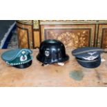 Two post war German visor caps and a WW2 style steel helmet with SS logo.