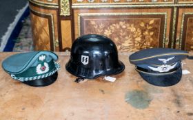 Two post war German visor caps and a WW2 style steel helmet with SS logo.