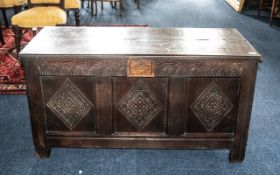 An Oak Coffer of Typical Form, with carved front and lift up lid.