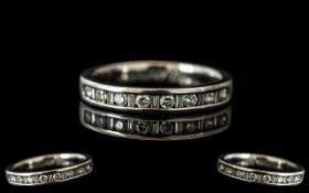 A Platinum Diamond Set Eternity Ring, channel set with alternating round brilliant and baguette