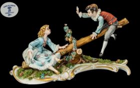 Capo di Monte Figural Piece, depicting a boy and girl on a see-saw, with a floral entwined base.
