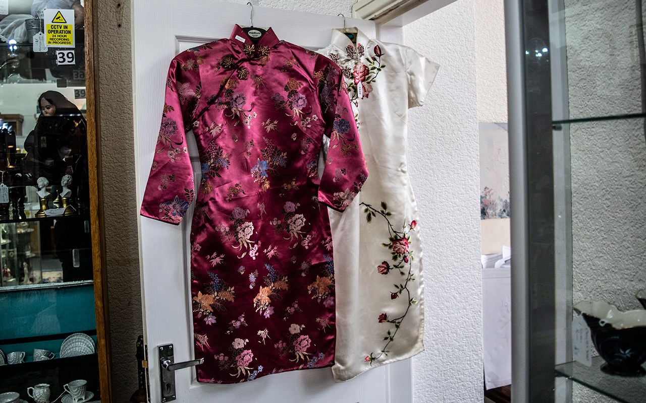 Two Chinese Silk Cheongsam Dresses, traditional style with side slits, comprising a pink floral