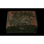 A Chinese Cinnabar Box floral decoration and hinged cover with black interior. Measures 4.5 by 3.