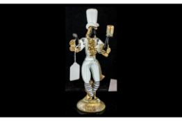 Murano Glass Figure of a Blackamoor, in white with gilt trims, figure holding aloft a candle holder,