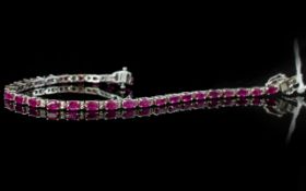 Ruby Tennis Bracelet, 11cts of oval cut rubies, interspaced with pairs of small white sapphires,
