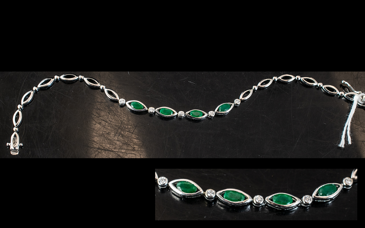 A 14ct White Gold Emerald and Diamond Bracelet central links set with alternating round cut diamonds