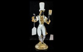 Murano Glass Figure of a Blackamoor, in white with gilt trims, figure holding aloft a candle holder,