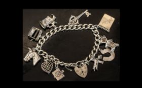 A Silver Charm Bracelet with padlock fastener with ten charms. Gross weight 52 grams.