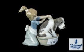 Lladro No. 5.455 depicting a sad looking dog being washed by a young girl.