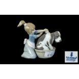 Lladro No. 5.455 depicting a sad looking dog being washed by a young girl.