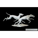 Kaiser Porcelain Bisque Figure Group of Two Running Dogs, Length 12 Inches.