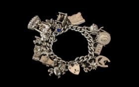 A Vintage Sterling Silver Charm Bracelet Loaded with 20 Silver Charms. All Marked for Silver.