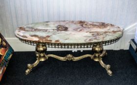 A Brass Oval Onyx Topped Coffee Table height 17 inches 42 by 18 inches deep.