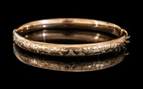 A 9ct Gold Hinged Bangle Floral Engraved Front, Wax Filled. Gross weight 13 grams.