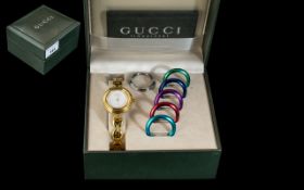 A Ladies Gucci Wristwatch with six coloured bezels. Gold plated watch and bracelet in fitted box.