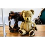 Pedigree Jointed Teddy Bear, height 20". Together with a carved elephant with bone tusks.