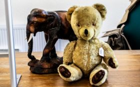 Pedigree Jointed Teddy Bear, height 20". Together with a carved elephant with bone tusks.