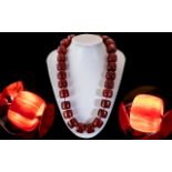 A Faux Cherry Amber Barrel Bead Necklace, each bead individually knotted. Length 60 cm.