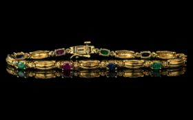 A 14ct Gold Gem Set Bracelet Set With Rubies, Sapphire and Emeralds With Diamond Spacers.