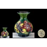 Moorcroft 'Hibiscus' Pattern Vase, 5.5" tall, dark green background with floral pattern.