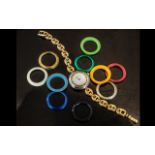 A Ladies Gucci Wrist Watch white dial with ten extra coloured bezels and gold plated bracelet.