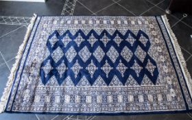Middle Eastern Rug in dark blue and cream with diamond pattern and fringing.