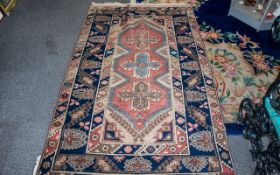 Middle Eastern Rug with central cross design, in pink, blue and cream with dark blue borders,