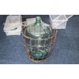 Victorian Green Oversized Glass Carboy Bottle, 32" tall, inside a metal caged basket.