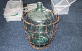 Victorian Green Oversized Glass Carboy Bottle, 32" tall, inside a metal caged basket.