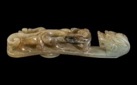 An Antique Chinese Jade Buckle Hook Stylised Carved Dragon. Length - 5 inches. Old repair to neck.