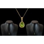 Ladies 9ct Gold - Mounted Pear Shaped Peridot Pendant Attached to a 9ct Gold Chain.