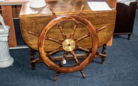 Ship's Wheel, a large brass mounted teak eight-spoke ship's wheel. 30'' diameter.
