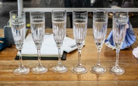 Six Tall Glass Champagne Flutes, with floral etching to top and star cut glass bowl, raised on a