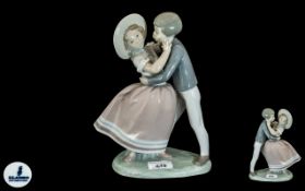 Lladro Figure Group depicting a young boy and girl dancing, height 10''.