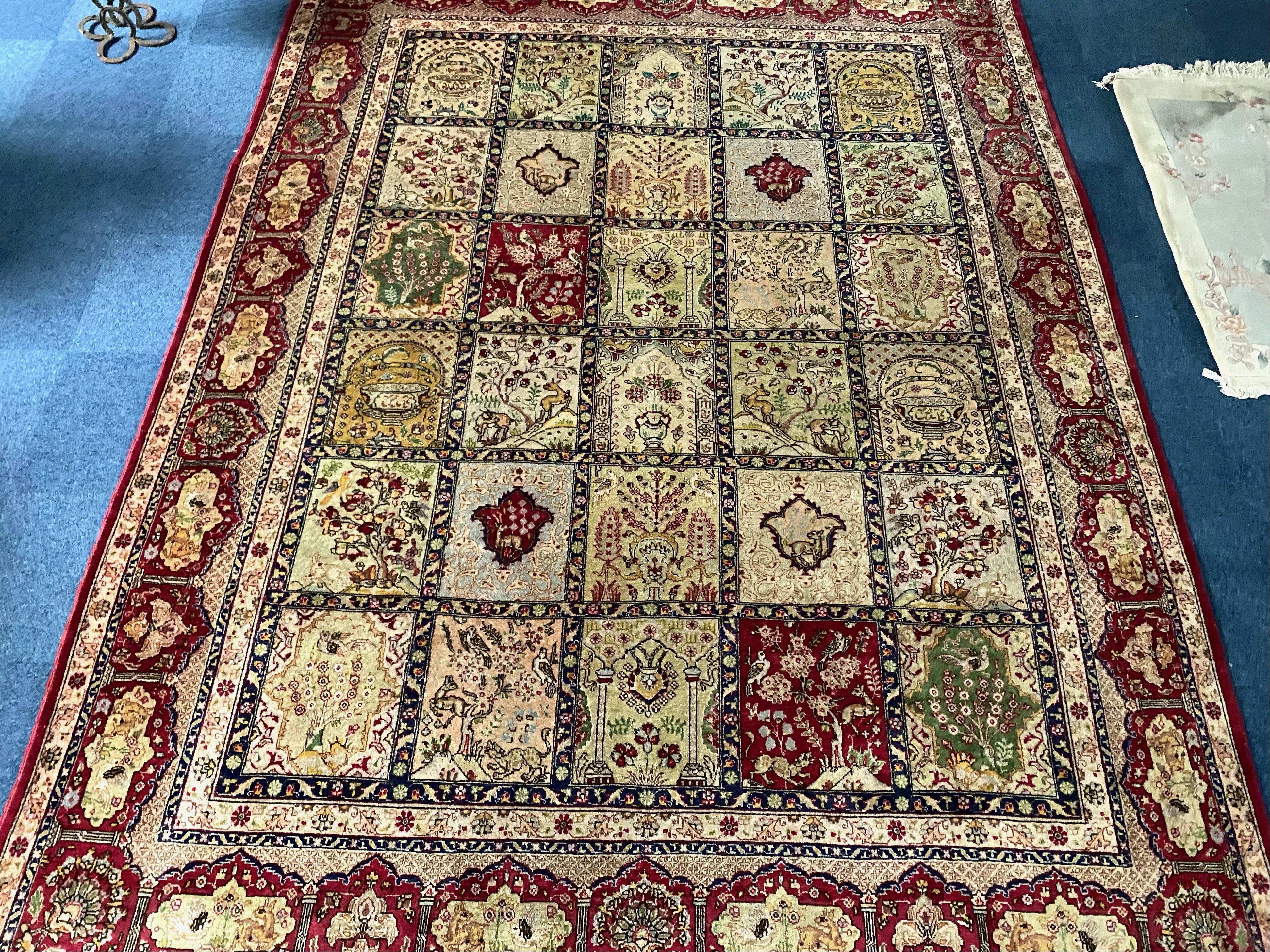 Large Wool Rug, Beige ground with red designs depicting animals, fruit trees, and flowers.