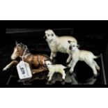 Four Beswick Animals, comprising a sheep 4" high x 4" long, and two lambs 3" and 2" tall.