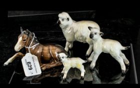 Four Beswick Animals, comprising a sheep 4" high x 4" long, and two lambs 3" and 2" tall.