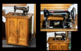 Vintage Gritzner German sewing machine housed in a wooden cabinet.