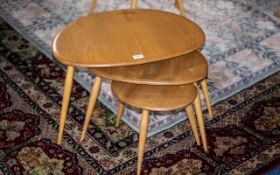 An Ercol Blonde Beech Nest Of Three Pebble/Elm Tables Largest Table 25 x 17 inches,