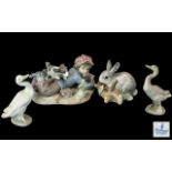 Four Lladro Figures, comprising two geese, a bunny rabbit and a boy reading with a puppy No. 5451.